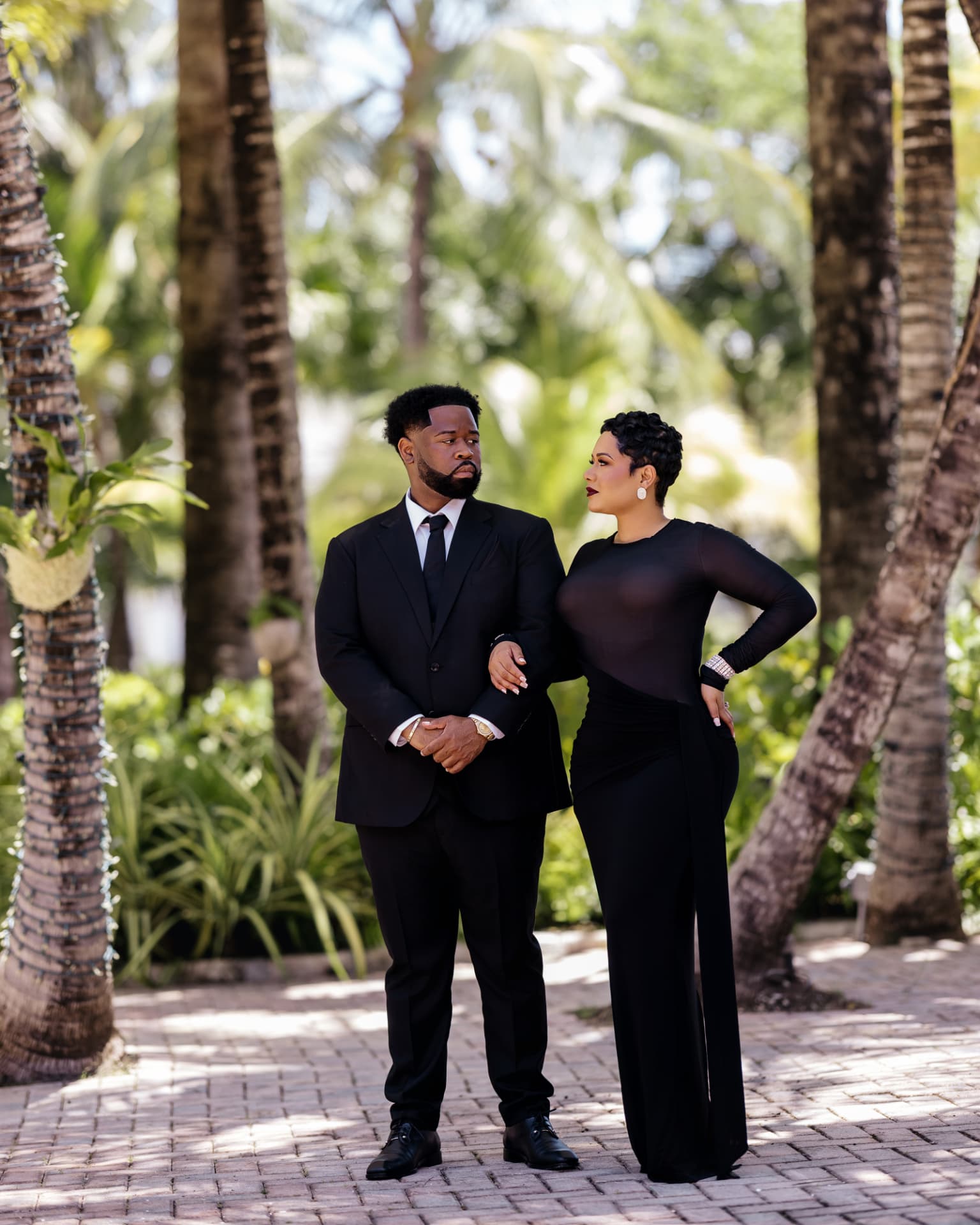 Lathario and Drew arm in arm among the palms, looking at one another